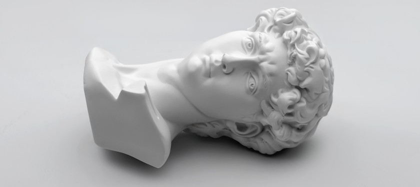 Element rzeźby, głowa młodego mężczyzny, w stylu greckim, w białym kolorze, leżąca na białym tle